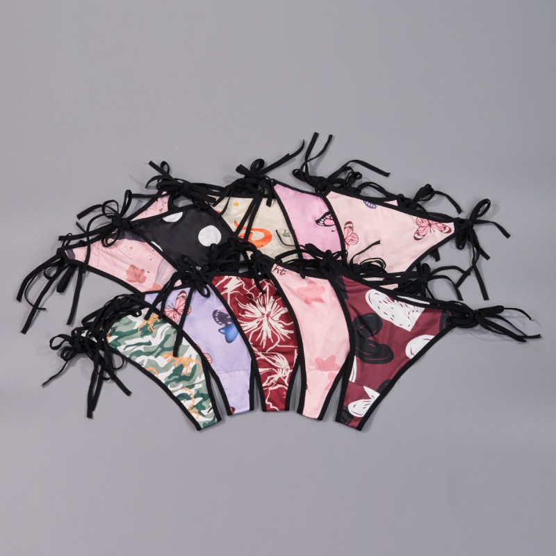 Plus-size tangové nohavičky s mašličkou a remienkami v štýle T, nízky pás, materiál milksilk (polyester 95–100%), intímna výstelka s elastanom, priedušné a antibakteriálne, náhodné potlače, balené po 10 kusov