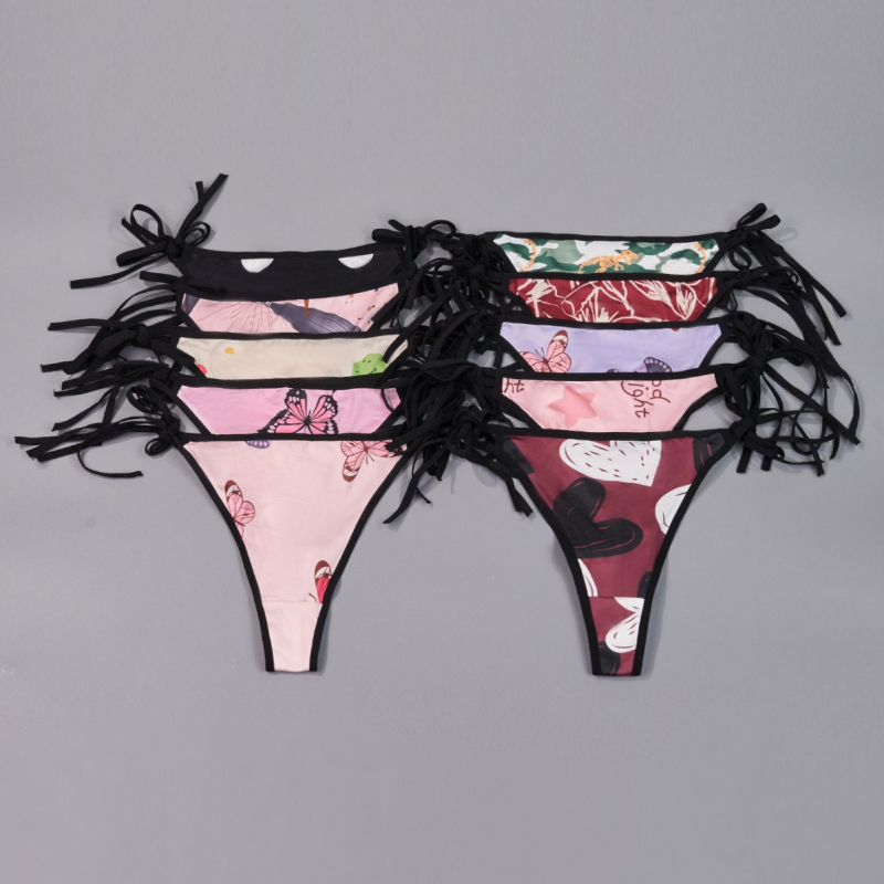 Plus-size tangové nohavičky s mašličkou a remienkami v štýle T, nízky pás, materiál milksilk (polyester 95–100%), intímna výstelka s elastanom, priedušné a antibakteriálne, náhodné potlače, balené po 10 kusov