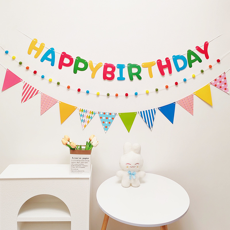 Detský banner k prvým narodeninám s pompónovými vlajkami — dekorácia na oslavu s nápisom Happy Birthday