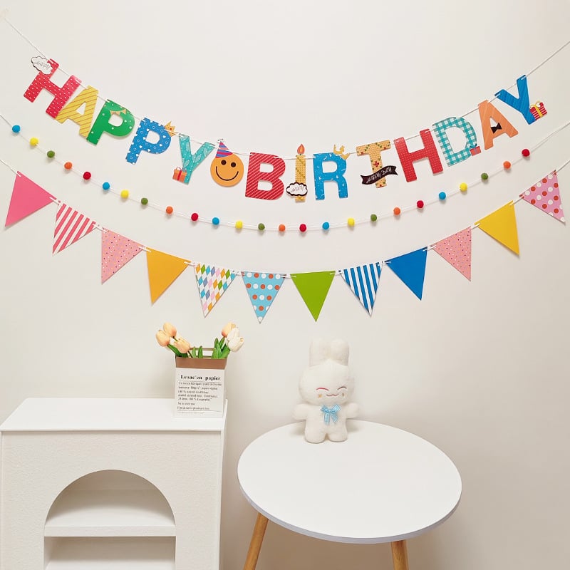 Detský banner k prvým narodeninám s pompónovými vlajkami — dekorácia na oslavu s nápisom Happy Birthday