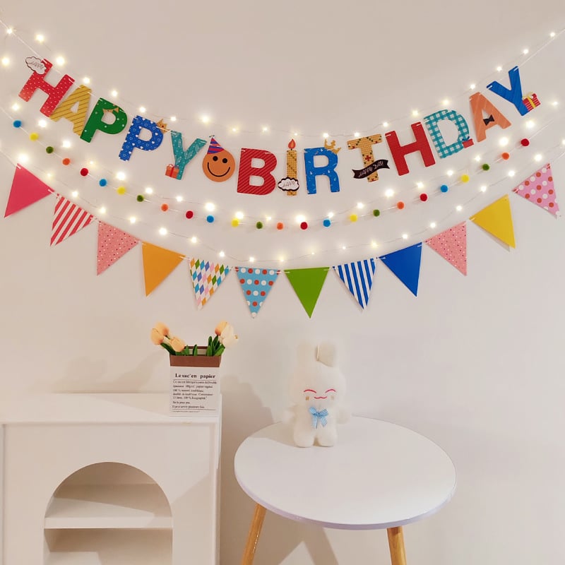 Detský banner k prvým narodeninám s pompónovými vlajkami — dekorácia na oslavu s nápisom Happy Birthday