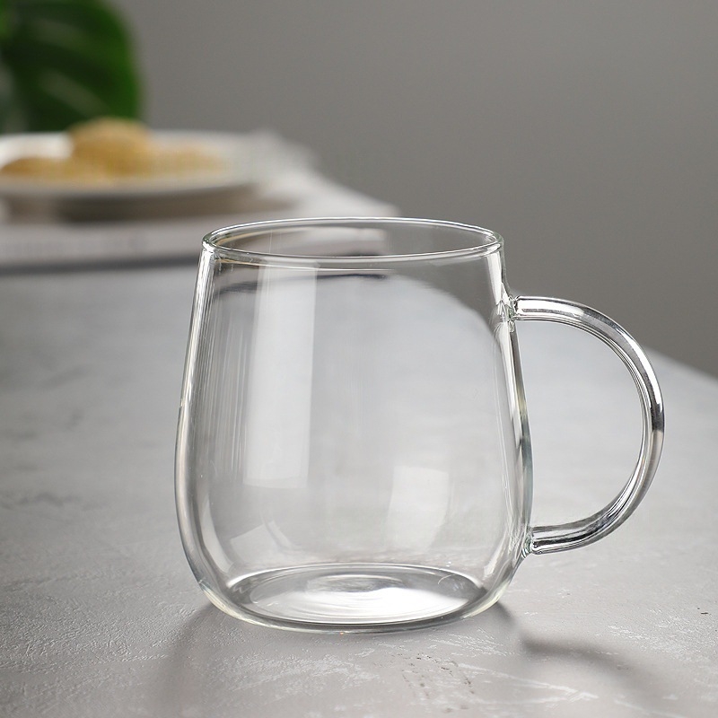Jednovrstvý pohár z borosilikátového skla s držadlom — nepravidelný tvar, tepelne odolný, kompatibilný s elektrickou platňou, na čaj a mlieko