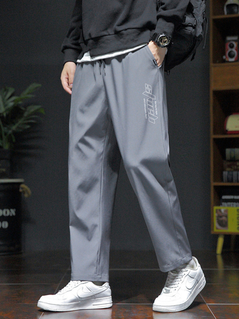 Pánske voľné športové nohavice, ľahký polyester s elastanom, stredný pás, šnúrka na stiahnutie, potlač s písmenami, leto