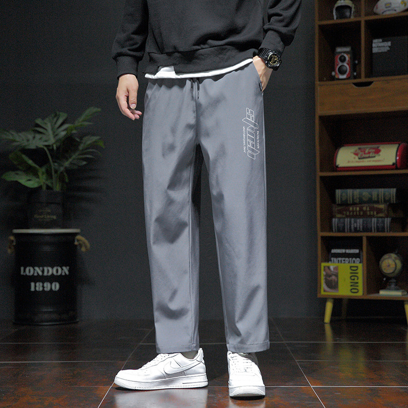Pánske voľné športové nohavice, ľahký polyester s elastanom, stredný pás, šnúrka na stiahnutie, potlač s písmenami, leto
