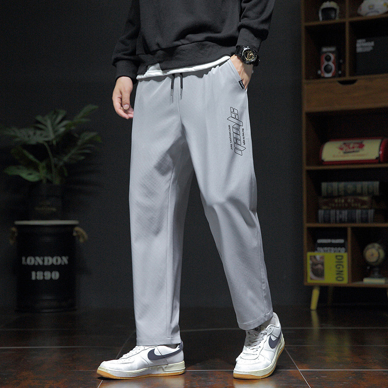 Pánske voľné športové nohavice, ľahký polyester s elastanom, stredný pás, šnúrka na stiahnutie, potlač s písmenami, leto