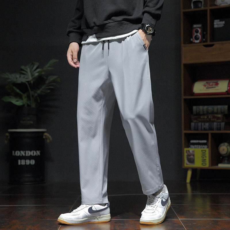 Pánske voľné športové nohavice, ľahký polyester s elastanom, stredný pás, šnúrka na stiahnutie, potlač s písmenami, leto