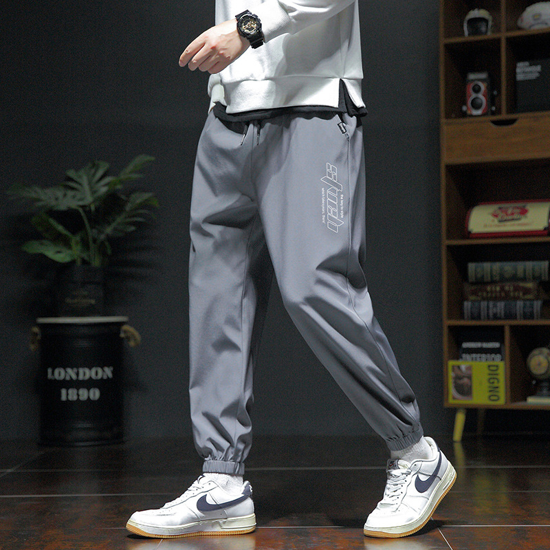 Pánske voľné športové nohavice, ľahký polyester s elastanom, stredný pás, šnúrka na stiahnutie, potlač s písmenami, leto