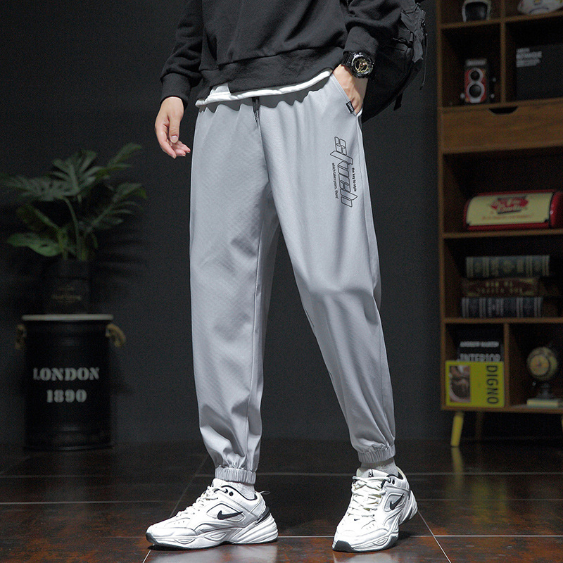 Pánske voľné športové nohavice, ľahký polyester s elastanom, stredný pás, šnúrka na stiahnutie, potlač s písmenami, leto