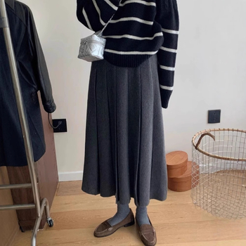 Lansiranje jesen 2024: A-linijska midi pletena plisirana suknja s visokim strukom, mikroelastična; glavni materijal: vuna mješavina (akril i spandeks); postotak glavnog materijala 30–50%.