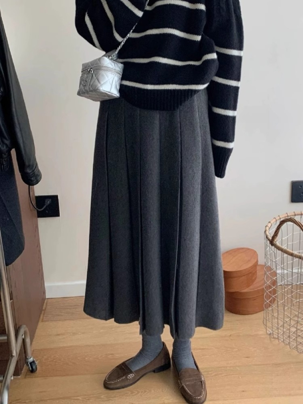 Lansiranje jesen 2024: A-linijska midi pletena plisirana suknja s visokim strukom, mikroelastična; glavni materijal: vuna mješavina (akril i spandeks); postotak glavnog materijala 30–50%.