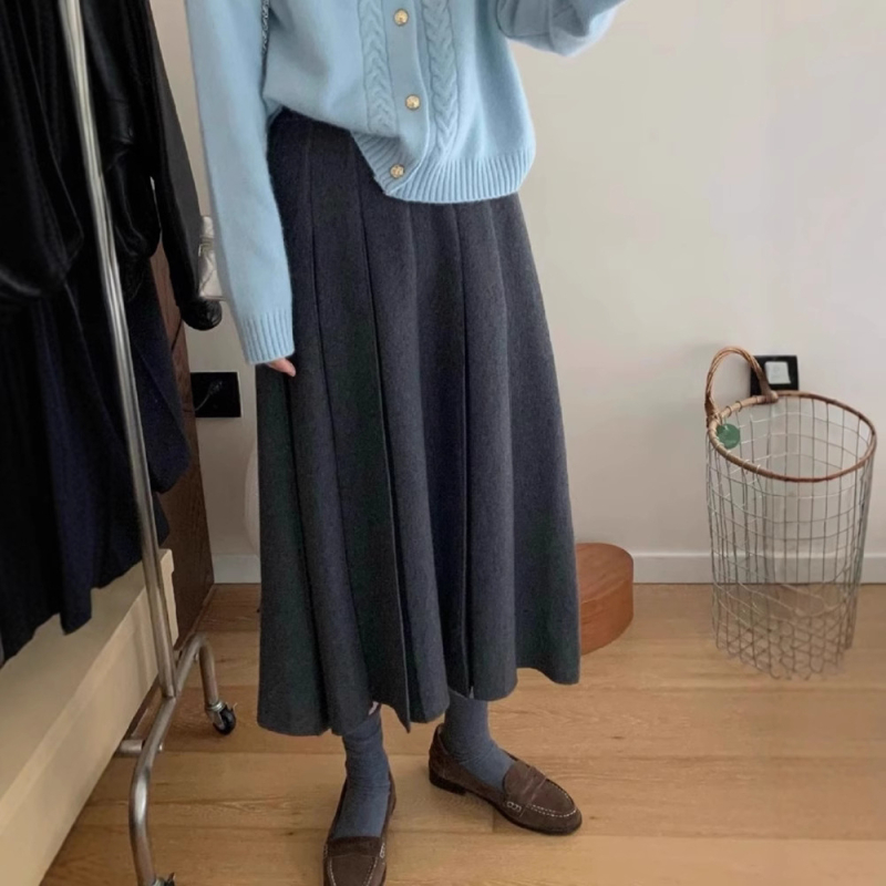 Lansiranje jesen 2024: A-linijska midi pletena plisirana suknja s visokim strukom, mikroelastična; glavni materijal: vuna mješavina (akril i spandeks); postotak glavnog materijala 30–50%.