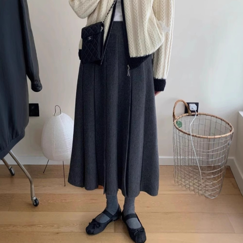 Lansiranje jesen 2024: A-linijska midi pletena plisirana suknja s visokim strukom, mikroelastična; glavni materijal: vuna mješavina (akril i spandeks); postotak glavnog materijala 30–50%.