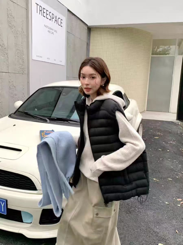 Dámska peľová vesta so stojacim golierom, zipsom, voľným strihom, výplňou z bieleho kačacieho peria, obsah peria 86–90%