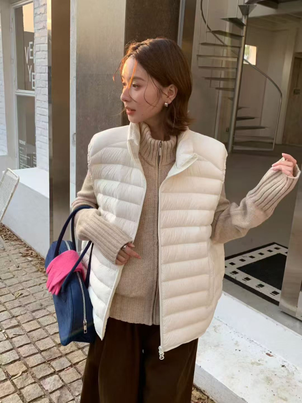 Dámska peľová vesta so stojacim golierom, zipsom, voľným strihom, výplňou z bieleho kačacieho peria, obsah peria 86–90%