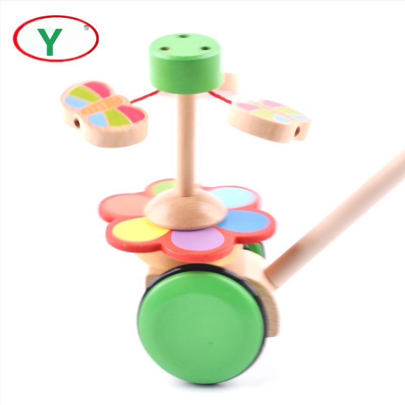 Koka gājienam paredzēta rotaļlieta zīdaiņiem 0–2 gadiem ar tauriņa rotējošu stieni; veicina jutību, vizuālo un kognitīvo attīstību un roku-acu koordināciju