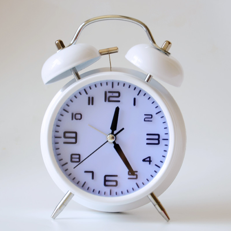 Kovový budík, napájaný batériou, elektronický pohyb, analógový ciferník s číslami, jednostranný, kovové puzdro a ciferník, moderný dizajn, zabudované budenie.