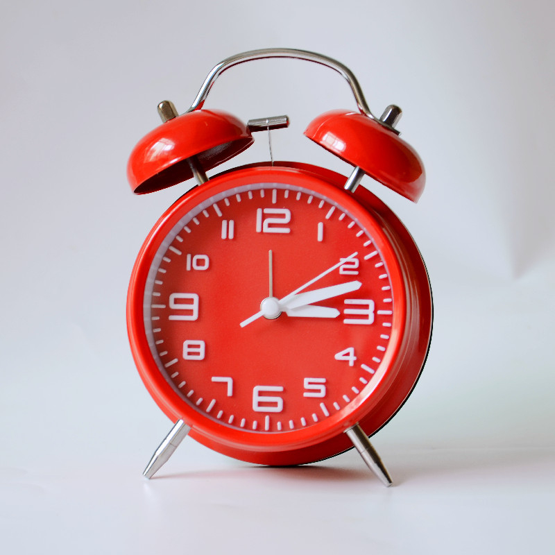Kovový budík, napájaný batériou, elektronický pohyb, analógový ciferník s číslami, jednostranný, kovové puzdro a ciferník, moderný dizajn, zabudované budenie.