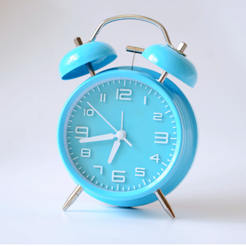 Kovový budík, napájaný batériou, elektronický pohyb, analógový ciferník s číslami, jednostranný, kovové puzdro a ciferník, moderný dizajn, zabudované budenie.