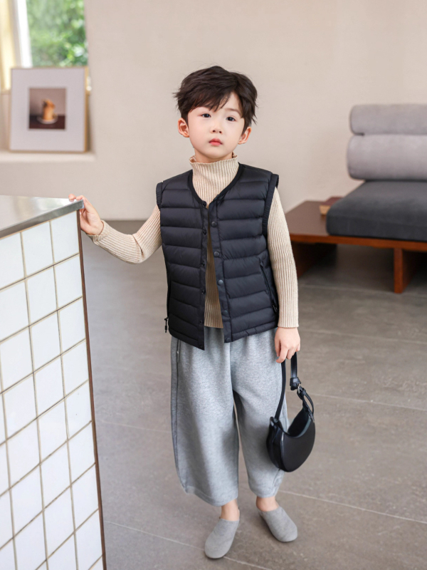 Gyerekeknek készült down mellény fehér kacsa tollal, töltet 91-94%, külső anyag nylon, bélés 100% nylon, rövid, ujj nélküli, gombos zárás, mindennapi téli viselet