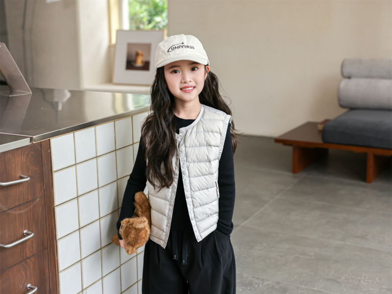 Gyerekeknek készült down mellény fehér kacsa tollal, töltet 91-94%, külső anyag nylon, bélés 100% nylon, rövid, ujj nélküli, gombos zárás, mindennapi téli viselet