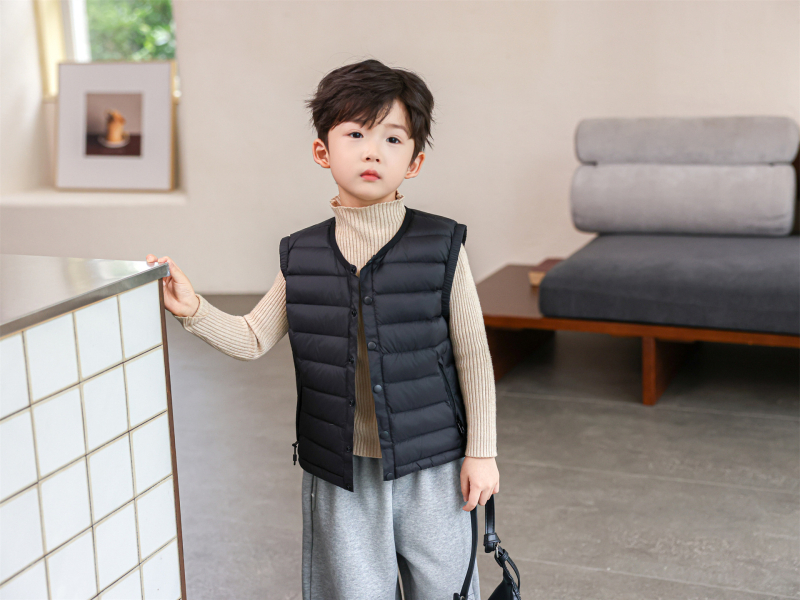 Gyerekeknek készült down mellény fehér kacsa tollal, töltet 91-94%, külső anyag nylon, bélés 100% nylon, rövid, ujj nélküli, gombos zárás, mindennapi téli viselet