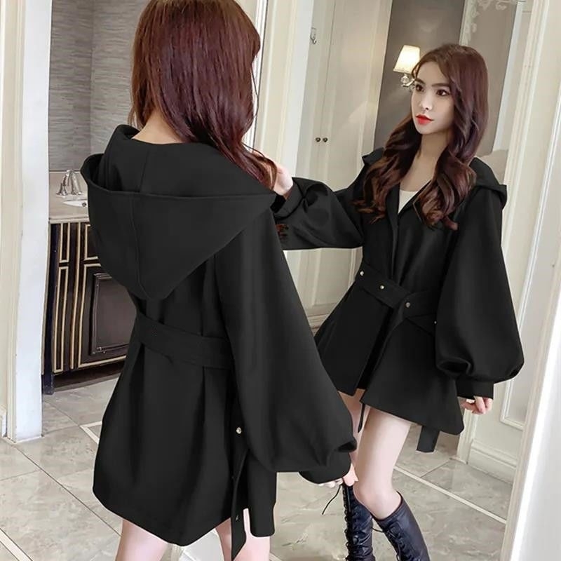 Īss trench jaka sievietēm - ar kapuci, laternu piedurknēm, ļoti īsa garums, A līnijas siluets, kokvilnas un poliesteres maisījums (90-95% poliestera)