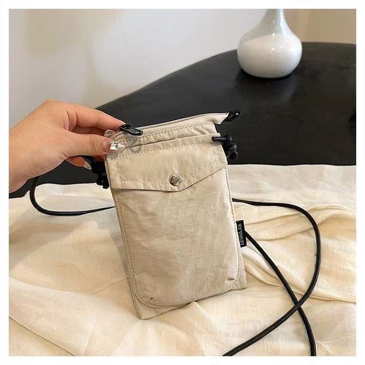 Telefonikott, nailon, linnaline lihtsus, vertikaalse ruudu kujuga, magnetlukustus, sees on telefoni tasku ja laminaat-tõmblukuga tasku