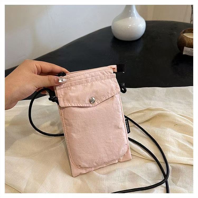 Telefonikott, nailon, linnaline lihtsus, vertikaalse ruudu kujuga, magnetlukustus, sees on telefoni tasku ja laminaat-tõmblukuga tasku