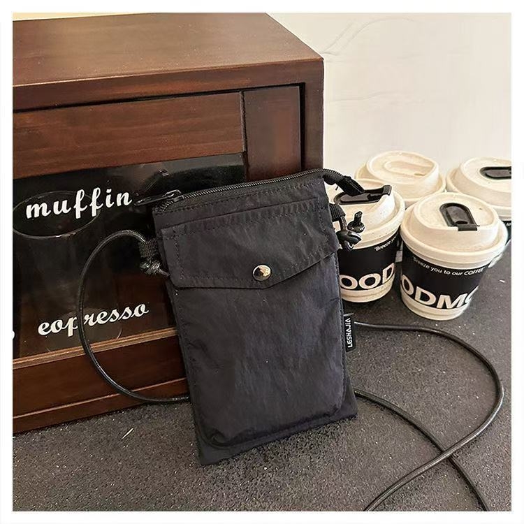 Telefonikott, nailon, linnaline lihtsus, vertikaalse ruudu kujuga, magnetlukustus, sees on telefoni tasku ja laminaat-tõmblukuga tasku