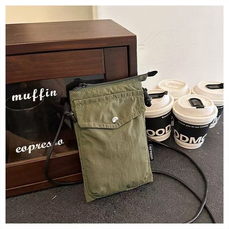 Telefonikott, nailon, linnaline lihtsus, vertikaalse ruudu kujuga, magnetlukustus, sees on telefoni tasku ja laminaat-tõmblukuga tasku