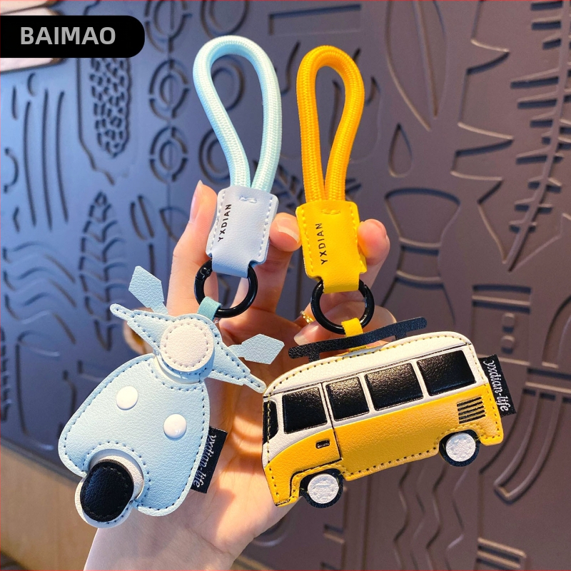 Ādas karikatūru atslēgu piekariņš ar transportlīdzekļu motīviem – automašīna, lidmašīna un autobuss