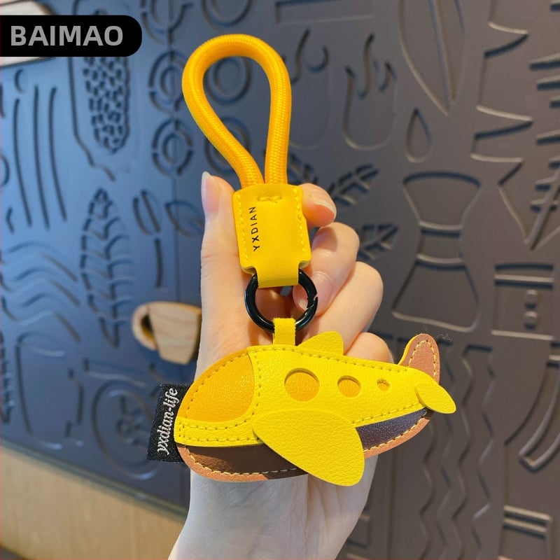 Ādas karikatūru atslēgu piekariņš ar transportlīdzekļu motīviem – automašīna, lidmašīna un autobuss