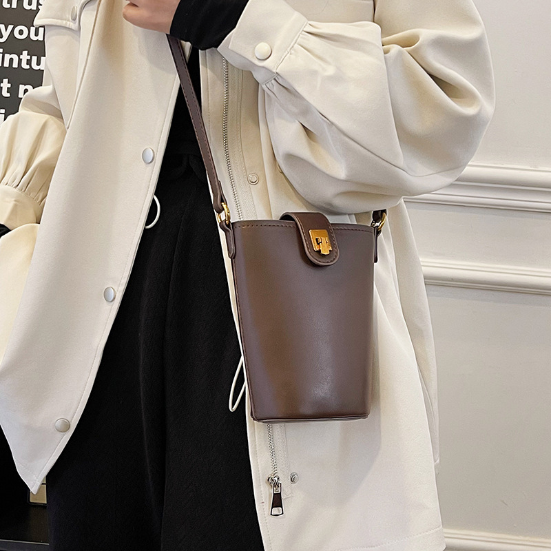 PU bucket kott vertikaalse ruudukujulise kujuga, klapiga suletav ja telefoni taskuga