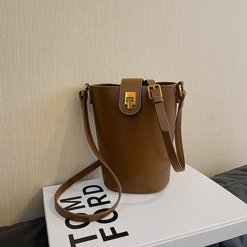 PU bucket kott vertikaalse ruudukujulise kujuga, klapiga suletav ja telefoni taskuga