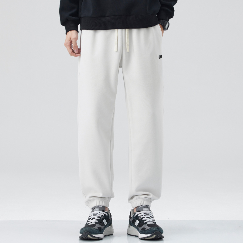 Vīriešu sporta bikses ar izšuvumu – brīvs piegriezums, josta ar auklu, kokvilnas-sintētiska maisījuma audums