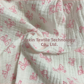 100% pamutból készült, dupla rétegű crepe muslin anyag, nyomtatott masni motívummal és tie-dye mintával; ideális babapizsamára, ágyneműre és otthoni viseletre