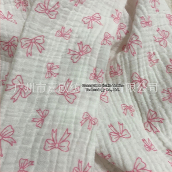 100% pamutból készült, dupla rétegű crepe muslin anyag, nyomtatott masni motívummal és tie-dye mintával; ideális babapizsamára, ágyneműre és otthoni viseletre