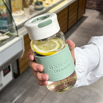 Стъклена чаша от боросиликатно стъкло с калъф за чаша — термоустойчива, изолирана и непроливаща.