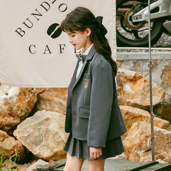 Meitenēm paredzēts īss jaka no kokvilnas maisījuma ar reveru, vienrindu pogu aizdari, vienkrāsains, garas piedurknes, piemērots vecumā no 8 gadiem (augstums >140 cm), skolas stils.