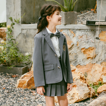 Meitenēm paredzēts īss jaka no kokvilnas maisījuma ar reveru, vienrindu pogu aizdari, vienkrāsains, garas piedurknes, piemērots vecumā no 8 gadiem (augstums >140 cm), skolas stils.