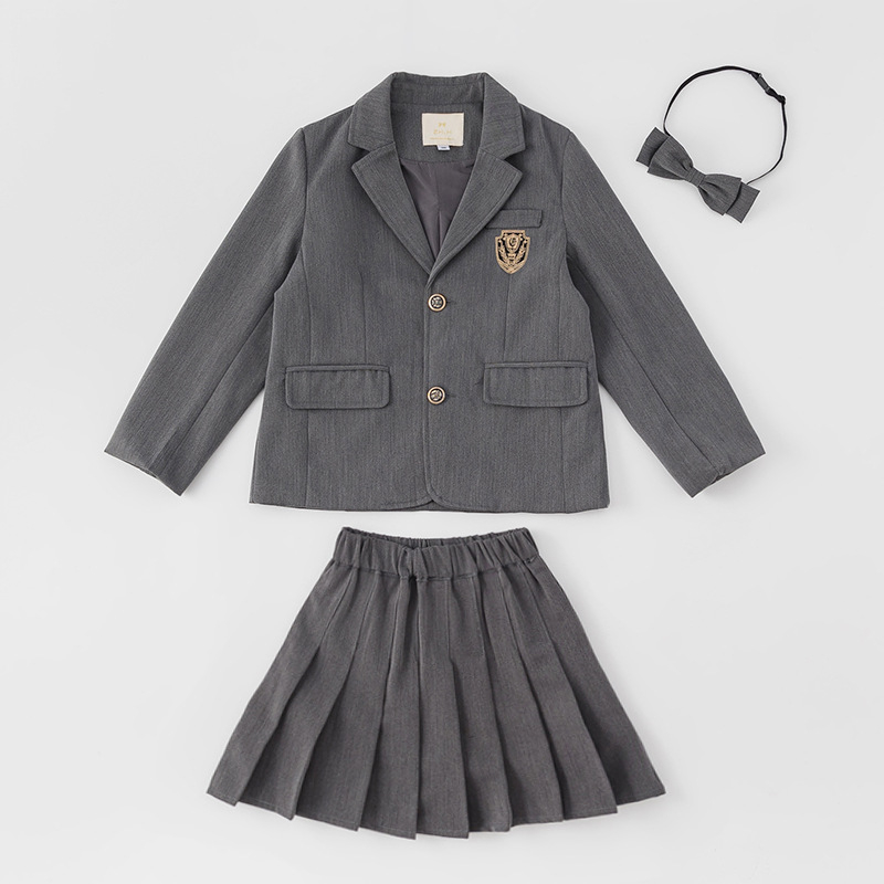 Meitenēm paredzēts īss jaka no kokvilnas maisījuma ar reveru, vienrindu pogu aizdari, vienkrāsains, garas piedurknes, piemērots vecumā no 8 gadiem (augstums >140 cm), skolas stils.