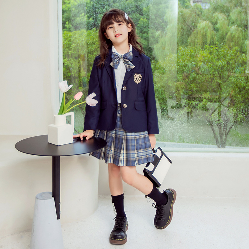 Meitenēm paredzēts īss jaka no kokvilnas maisījuma ar reveru, vienrindu pogu aizdari, vienkrāsains, garas piedurknes, piemērots vecumā no 8 gadiem (augstums >140 cm), skolas stils.