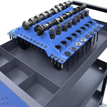 Variklio techninės priežiūros darbo stalas: plastikinė plokštė įsiurbimo/ išmetimo dalių išdėstymui — cilindro galvos varžtai, vožtuvo svirčių rankos, viršutinės talpyklos ir vožtuvo spyruoklių vietos