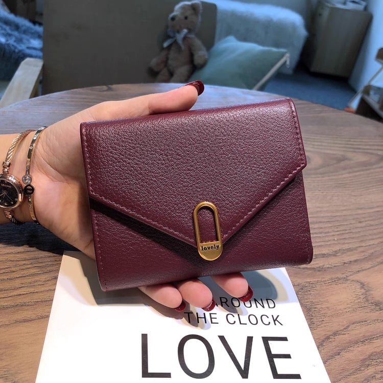 Moteriška piniginė iš tikros odos iš pirmojo sluoksnio; užsegimas sagtimi; viduje banknotų kilpa, nuotraukų vieta, ID langelis ir kortelių skyriai; horizontali kvadrato forma; miesto paprastumo stilius.