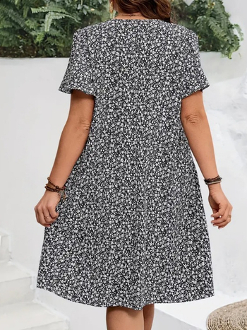 V kaklo iškirptė, išskleistas gėlių raštas su suplyšusiu motyvu, trumpomis volanomis rankovėmis, skėtis tipo suknelė, poliesteris su spandeksu