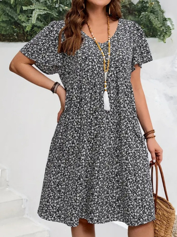 V kaklo iškirptė, išskleistas gėlių raštas su suplyšusiu motyvu, trumpomis volanomis rankovėmis, skėtis tipo suknelė, poliesteris su spandeksu