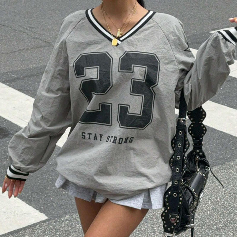 Poliesterio marškinėliai, skaitmeninė spauda su raidėmis ir skaitmenimis, ilgos rankovės, V formos kaklo iškirptė, laisvas kirpimas.