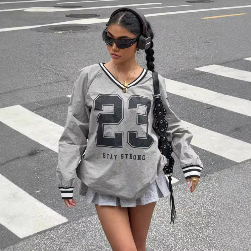 Poliesterio marškinėliai, skaitmeninė spauda su raidėmis ir skaitmenimis, ilgos rankovės, V formos kaklo iškirptė, laisvas kirpimas.