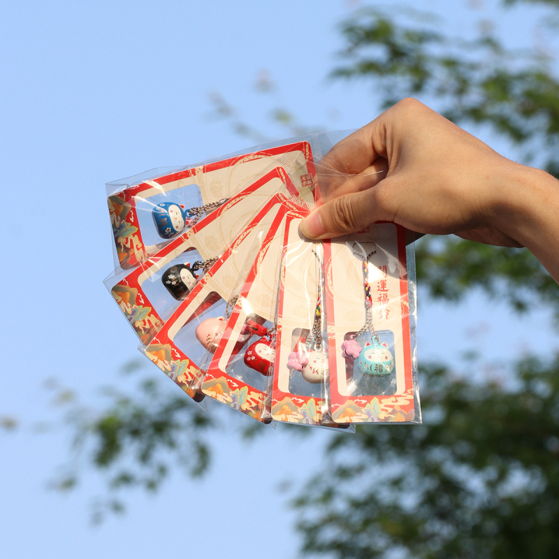 Metalo varpelio pakabukas su laimingos katės ir vyšnios žiedų motyvais