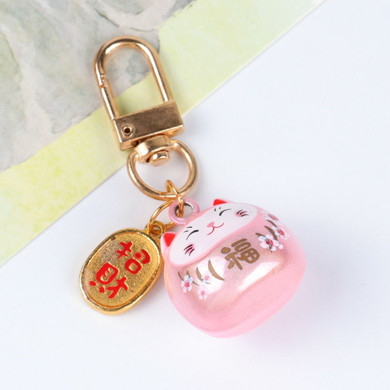 Metalo varpelio pakabukas su laimingos katės ir vyšnios žiedų motyvais